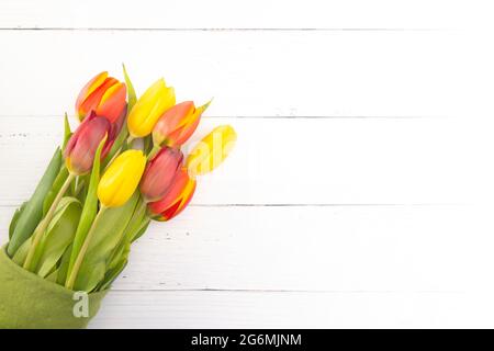 Una disposizione di bei tulipani di primavera su un tavolo di legno bianco Foto Stock