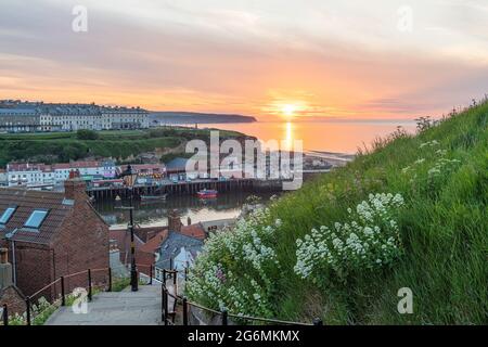 Il sole tramonta sull'orizzonte ai 199 gradini di Whitby Foto Stock