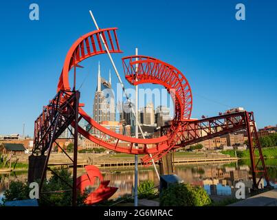 Nashville, Tennessee - 28 giugno 2021: Balletto fantasma per la East Bank Machine Works scultura incornicia lo skyline di Nashville Foto Stock