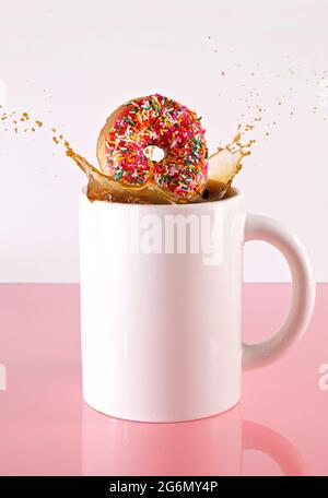 Ciambelle in una tazza gigante di caffè nero Foto Stock