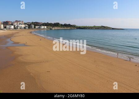 Persone che camminano sulla spiaggia in una soleggiata primavera mattina Sardinero Santander Cantabria Spagna Foto Stock