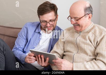 Ritratto closeup, famiglia, giovane uomo che tiene il pollice più vecchio manshowing in su Foto Stock