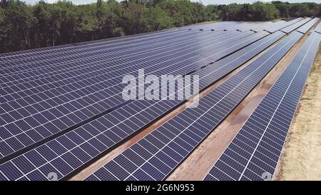 Drone vista ad alto angolo di pannelli di energia solare durante la giornata di sole. Fotovoltaico sistema fotovoltaico in matrice solare di una fattoria solare. Foto Stock