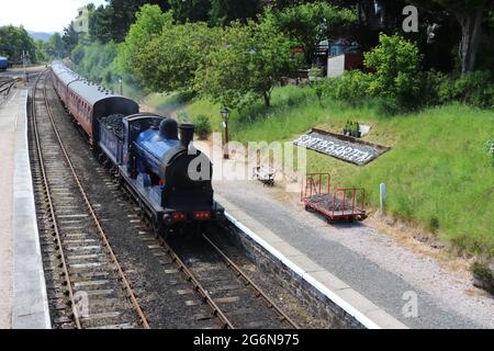 Vecchio treno a vapore in arrivo in stazione Foto Stock