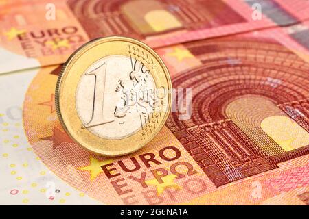Primo piano di una moneta in euro sulle banconote in euro. Foto Stock