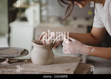 Giovane donna che fa ceramica in studio. Foto Stock