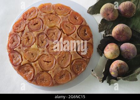 Fico torta capovolta con un sacco di fichi freschi e aromatizzato con succo d'arancia fresco. Scatto su sfondo bianco Foto Stock