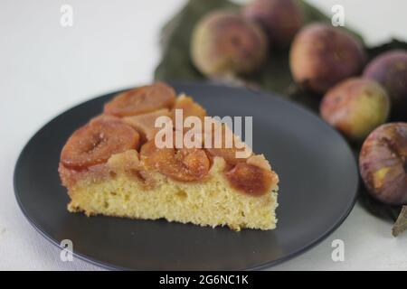 Fetta di fichi torta capovolta con un sacco di fichi freschi e aromatizzati con succo d'arancia fresco. Scatto su sfondo bianco. Foto Stock