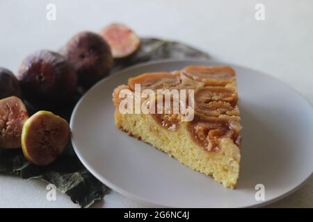 Fetta di fichi torta capovolta con un sacco di fichi freschi e aromatizzati con succo d'arancia fresco. Scatto su sfondo bianco. Foto Stock