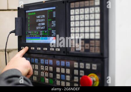 Il processo di programmazione di una macchina CNC. Inserimento dei dati in una macchina controllata da computer, avvio incisione CNC, schermata di controllo. Produttore di mobili Foto Stock