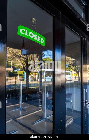 Riflessioni nelle finestre del bar chiuso con cartello chiuso, a Balmain, Sydney Australia durante il blocco pandemico Foto Stock