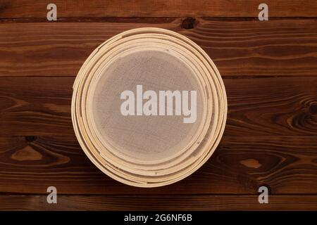 Antico setaccio tradizionale di farina, in legno di faggio e rete metallica fine, su fondo marrone. Impostare per setacciare la farina prima di cuocere e cuocere. In alto Foto Stock