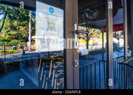 Riflessioni in finestre di bar chiuso con codice QR check in, a Balmain, Sydney Australia durante il blocco pandemico Foto Stock