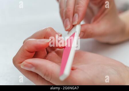 Donna che fa manicure con lima del chiodo. Concetto domestico di cura delle unghie. Foto Stock