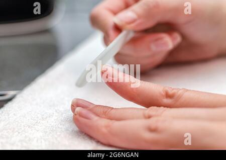 Donna si fa un manicure con un file unghia a home.Hygiene e cura unghie. Foto Stock