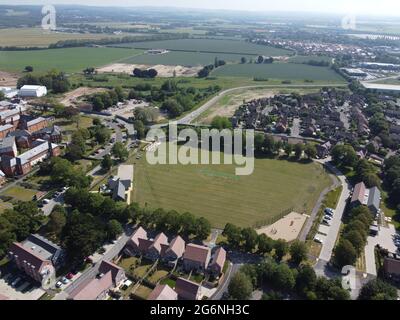 Vista aerea del Keepers Field sulla tenuta Graylingwell a Chichester, West Sussex con Goodwood Aerodromo / circuito a motore in lontananza. Foto Stock