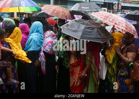 Dhaka, Bangladesh. 07 luglio 2021. La gente sta in piedi sotto la pioggia per comprare i prodotti sovvenzionati dal governo dai camion di TCB. Mentre il governo dichiara un arresto per la rapida diffusione del covid-19 ma non mantengono alcuna distanza sociale per prevenire il virus a Dhaka, Bangladesh il 7 luglio 2021. (Foto di Mir Hossen Roney/Pacific Press) Credit: Pacific Press Media Production Corp./Alamy Live News Foto Stock