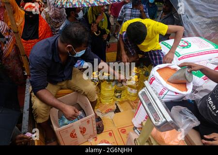 Dhaka, Bangladesh. 07 luglio 2021. La gente sta in piedi sotto la pioggia per comprare i prodotti sovvenzionati dal governo dai camion di TCB. Mentre il governo dichiara un arresto per la rapida diffusione del covid-19 ma non mantengono alcuna distanza sociale per prevenire il virus a Dhaka, Bangladesh il 7 luglio 2021. (Foto di Mir Hossen Roney/Pacific Press) Credit: Pacific Press Media Production Corp./Alamy Live News Foto Stock