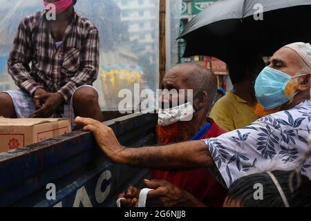 Dhaka, Bangladesh. 07 luglio 2021. La gente sta in piedi sotto la pioggia per comprare i prodotti sovvenzionati dal governo dai camion di TCB. Mentre il governo dichiara un arresto per la rapida diffusione del covid-19 ma non mantengono alcuna distanza sociale per prevenire il virus a Dhaka, Bangladesh il 7 luglio 2021. (Foto di Mir Hossen Roney/Pacific Press) Credit: Pacific Press Media Production Corp./Alamy Live News Foto Stock