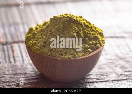 Ciotola di polvere di Matcha di tè verde su un tavolo di Woodn Foto Stock