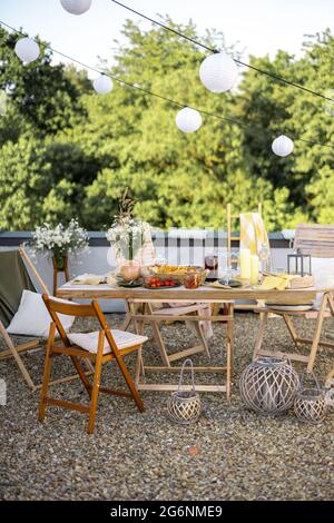 Terrazza sul tetto splendidamente decorata con un tavolo da pranzo Foto Stock