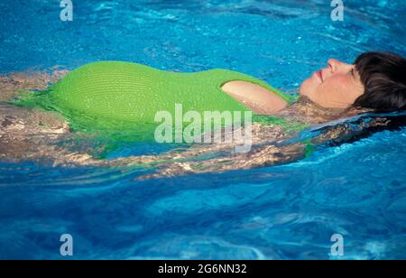 Donna incinta nuoto Foto Stock