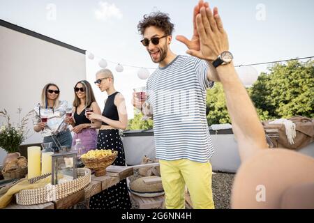 Gli amici si rilassano sulla terrazza sul tetto Foto Stock