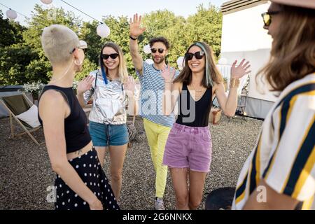 I giovani amici alla moda saluta alla festa all'aperto Foto Stock