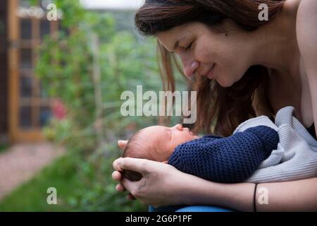 Una madre che guarda il suo bambino Foto Stock