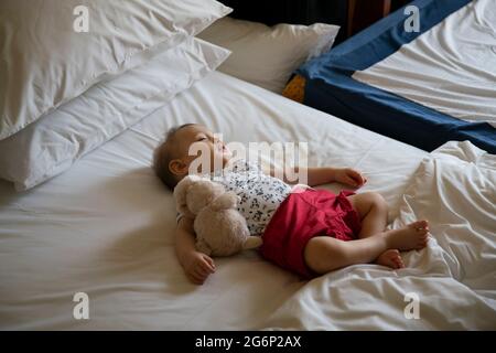 Un ragazzo di un anno che dormiva su un letto Foto Stock