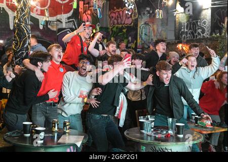 Digbeth, Birmingham, Regno Unito 7 luglio 2021 i tifosi festeggiano un gol contro la Danimarca nella semifinale Euro 2020 tempo extra. I fan sono scoppiati mentre guardavano al bar popup Big Fang sotto gli archi ferroviari nel centro di Birmingham. PIC by Credit: Sam Holiday/Alamy Live News Foto Stock