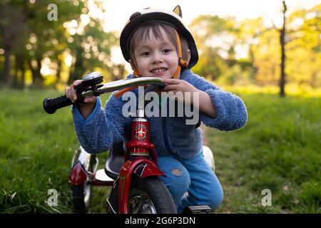 Un ragazzo con un triciclo Foto Stock