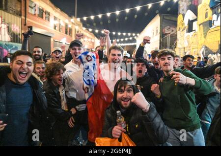 Digbeth, Birmingham 7 luglio 2021 - i tifosi festeggiano sotto gli archi a Digbeth, Birmingham, mentre l'Inghilterra batte la Danimarca nelle semifinali di Euro 2020. Le auto erano sommerse da masse di persone giubilanti che si unirono alla festa di strada. Fig. Per credito: Interrompi stampa Media/Alamy Live News Foto Stock