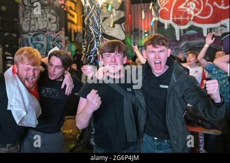 Digbeth, Birmingham 7 luglio 2021 - i tifosi festeggiano sotto gli archi a Digbeth, Birmingham, mentre l'Inghilterra batte la Danimarca nelle semifinali di Euro 2020. Le auto erano sommerse da masse di persone giubilanti che si unirono alla festa di strada. Fig. Per credito: Interrompi stampa Media/Alamy Live News Foto Stock