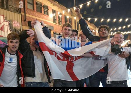 Digbeth, Birmingham 7 luglio 2021 - i tifosi festeggiano sotto gli archi a Digbeth, Birmingham, mentre l'Inghilterra batte la Danimarca nelle semifinali di Euro 2020. Le auto erano sommerse da masse di persone giubilanti che si unirono alla festa di strada. Fig. Per credito: Interrompi stampa Media/Alamy Live News Foto Stock