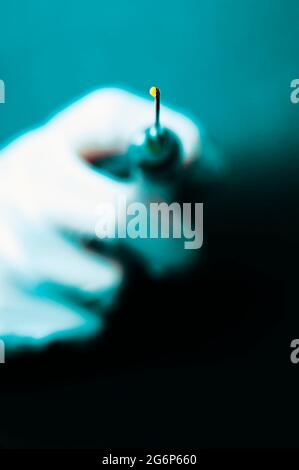 La mano guantata tenendo la siringa Foto Stock