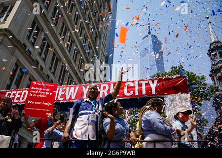 New York, Stati Uniti. 7 Lug 2021. I lavoratori essenziali ondeggiano da un galleggiante di fronte al One World Trade Center durante una sfilata di Hometown Heroes ticker tape attraverso il Canyon of Heroes a New York, USA. La parata ha onorato la salute e gli operatori essenziali che hanno aiutato la città attraverso la pandemia COVID-19. Credit: Chase Sutton/Alamy Live News Foto Stock