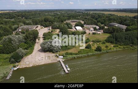 06 luglio 2021, Meclemburgo-Pomerania occidentale, Ribnitz-Dangarten: Il Museo della tecnologia di Pütnitz con le sue tre sale espositive, ex hangar aerei. Il museo è situato su un ex campo militare, che è stato costruito nel 1935 e fu utilizzato dalle truppe russe fino al 1994. In tre sale viene presentata la 'tecnologia dell'ex blocco orientale', nel terreno all'aperto si può partecipare ad attività di guida con veicoli militari e autobus tra gli altri. L'Associazione degli amici e sponsor del Museo tecnico riceverà una sovvenzione dal Fondo Vorpommern il 08.07.2021. (Vista aerea con una Foto Stock