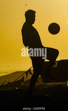 San Salvador, El Salvador. 07 luglio 2021. Un uomo gioca a calcio alla spiaggia di San Marcelino al tramonto. Credit: SOPA Images Limited/Alamy Live News Foto Stock