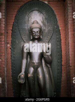 Antico statuto del Buddha Nero situato accanto allo Swayambhu Stupa a Kathmandu, Nepal Foto Stock