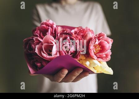 Una donna tiene in mano un bouquet di tulipani rosa. Il concetto di dono per la Festa della mamma, 8 marzo e altre festività Foto Stock