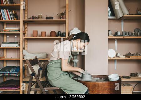Laboratorio di ceramica. pentole di creta contro lo sfondo di un tornio del  vasaio, fatta a mano Foto stock - Alamy