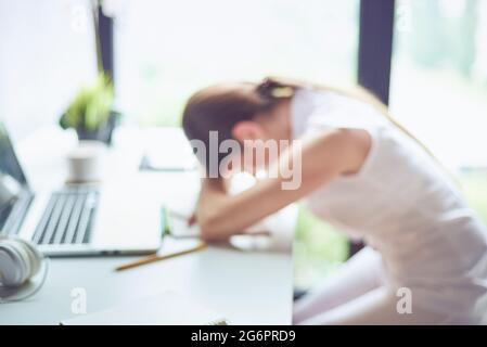 Foto sfocata di una giovane donna che si annoiava e si sentiva frustrata, professionista creativo sul suo posto di lavoro che dormiva su un laptop. Una giovane donna stanca fallina Foto Stock