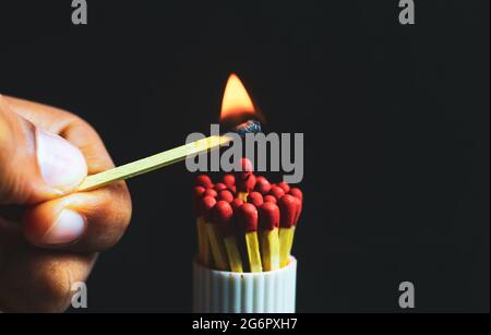 Sindrome di Burnout, stress, esaurimento e concetto di equilibrio vita-lavoro. Primo piano di una singola partita bruciata in un gruppo di partite. Un uomo in piedi. Foto Stock