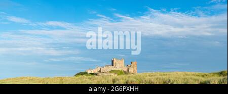 Vista panoramica che mostra il Castello di Bamburgh lungo la costa durante l'estate, a Bamburgh, Northumberland, Regno Unito Foto Stock