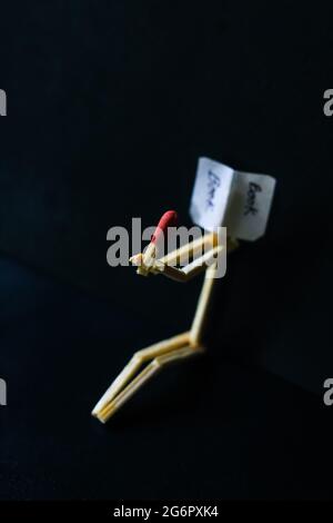 Concetto e idee di matchstick. Concetto e idee di lettura del libro. Matchstick lettura di un libro con uno sfondo nero. Foto Stock