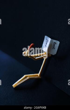 Concetto e idee di matchstick. Concetto e idee di lettura del libro. Matchstick lettura di un libro con uno sfondo nero. Foto Stock