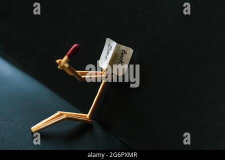 Concetto e idee di matchstick. Concetto e idee di lettura del libro. Matchstick lettura di un libro con uno sfondo nero. Foto Stock