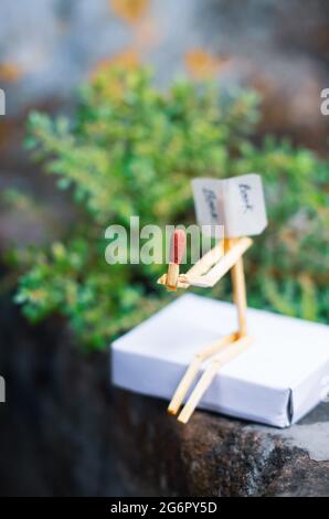 Concetto e idee di matchstick. Concetto e idee di lettura del libro. Matchstick lettura di un libro con sfondo verde. Foto Stock