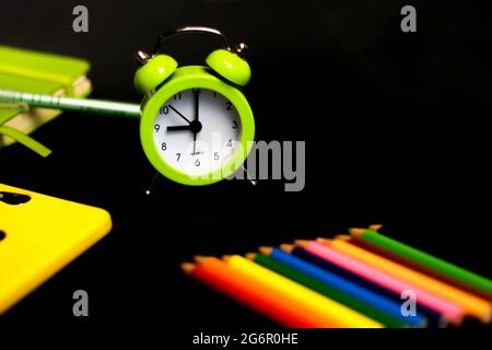 Ritorno a scuola con matite colorate e sveglia. Concetto con spazio per il testo o altri elementi sul tema della scuola e del tempo gestire Foto Stock